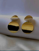 Montreal-based gold statement earrings against white background