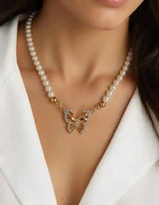 Gold butterfly charm necklace paired with pearl strand